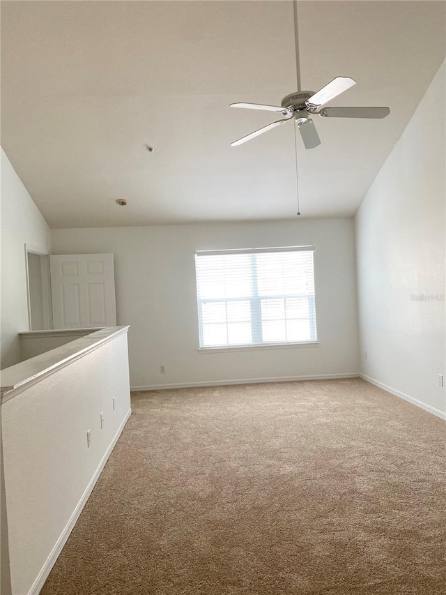 unfurnished room featuring light carpet, baseboards, lofted ceiling, and ceiling fan