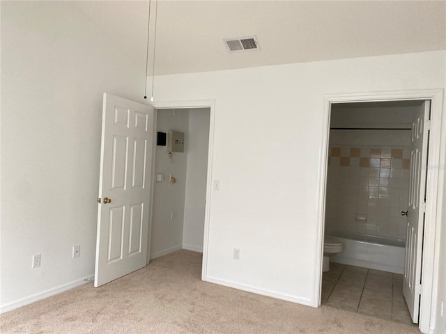 unfurnished bedroom with baseboards, carpet floors, connected bathroom, and visible vents
