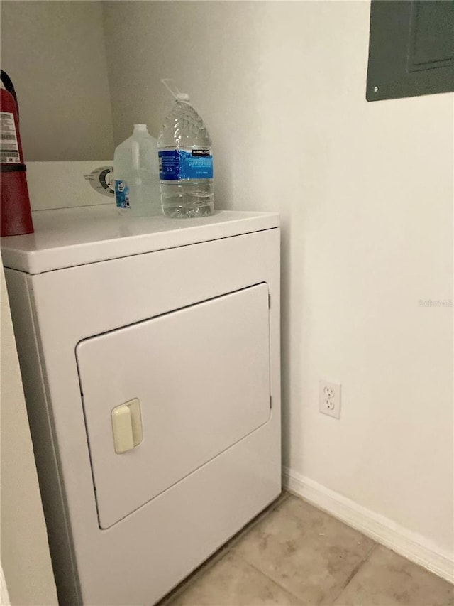 laundry area with baseboards, laundry area, electric panel, and washer / dryer