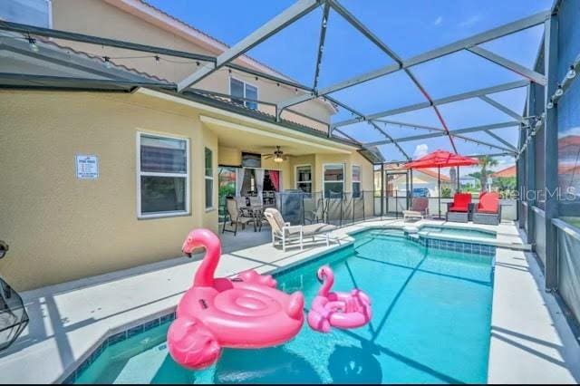 view of swimming pool featuring glass enclosure and a patio