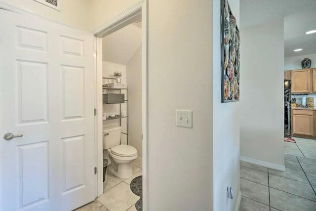 bathroom with toilet and tile patterned flooring