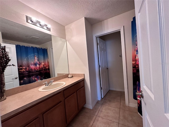 bathroom featuring tile patterned flooring, vanity, and a textured ceiling