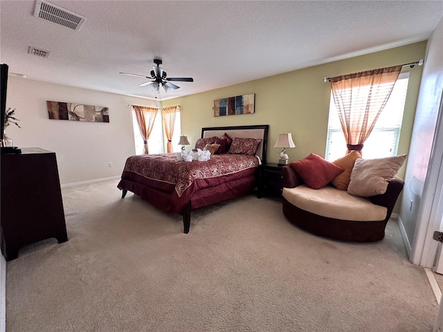 carpeted bedroom featuring a textured ceiling and ceiling fan