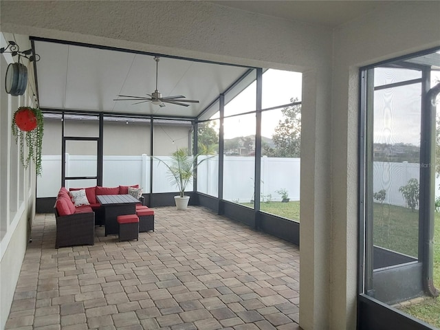 sunroom / solarium with a water view, ceiling fan, and a healthy amount of sunlight