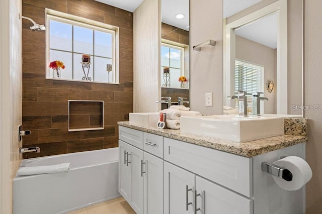 bathroom with tile patterned flooring, vanity, and tiled shower / bath