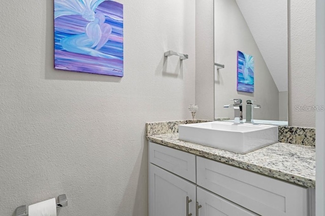 bathroom with vanity and vaulted ceiling