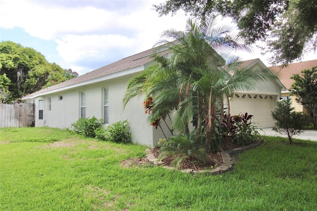 view of home's exterior with a garage and a lawn