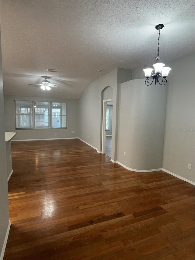 unfurnished room with dark wood-type flooring, a textured ceiling, ceiling fan with notable chandelier, and lofted ceiling