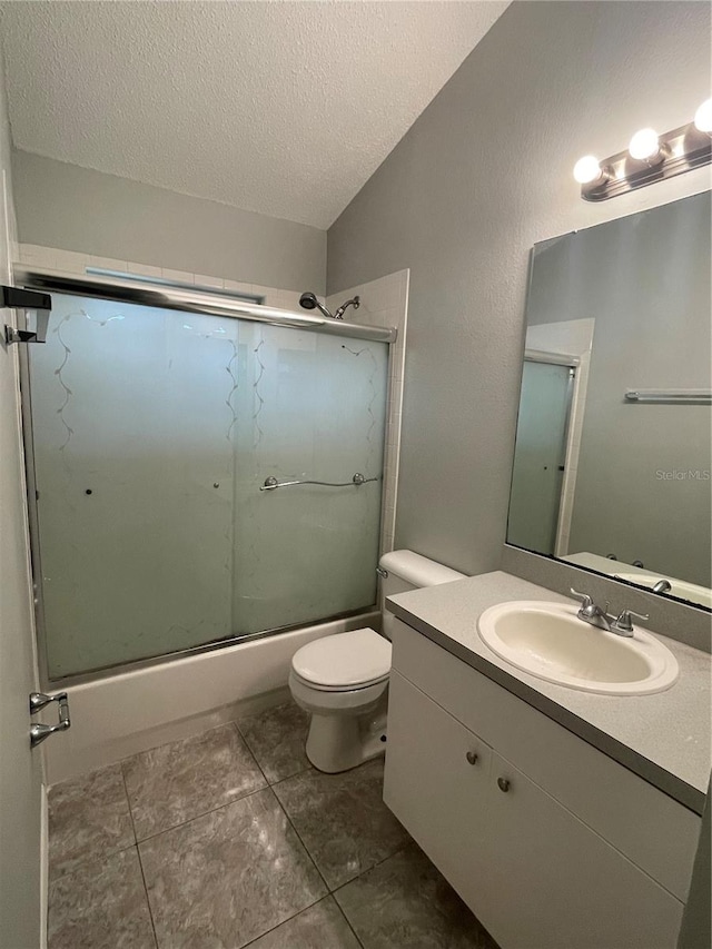 full bathroom with a textured ceiling, lofted ceiling, tile patterned floors, toilet, and vanity