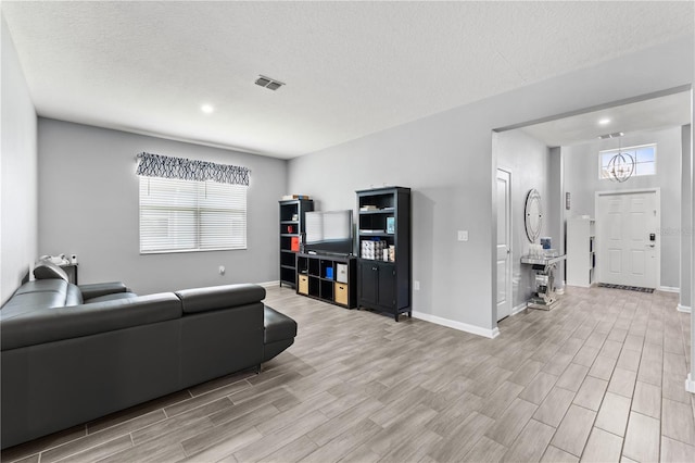 living room with light hardwood / wood-style floors and a textured ceiling