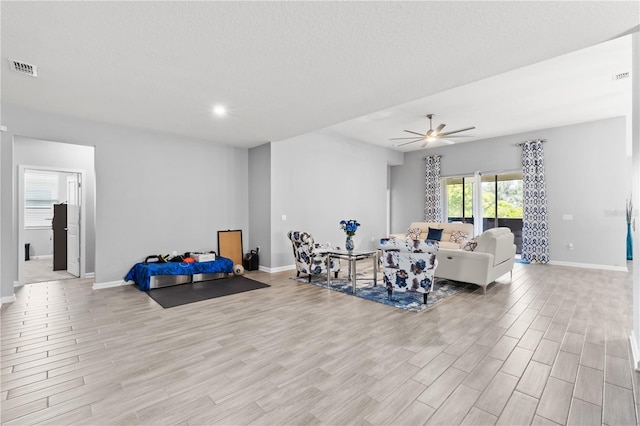 sitting room with ceiling fan and light wood-type flooring