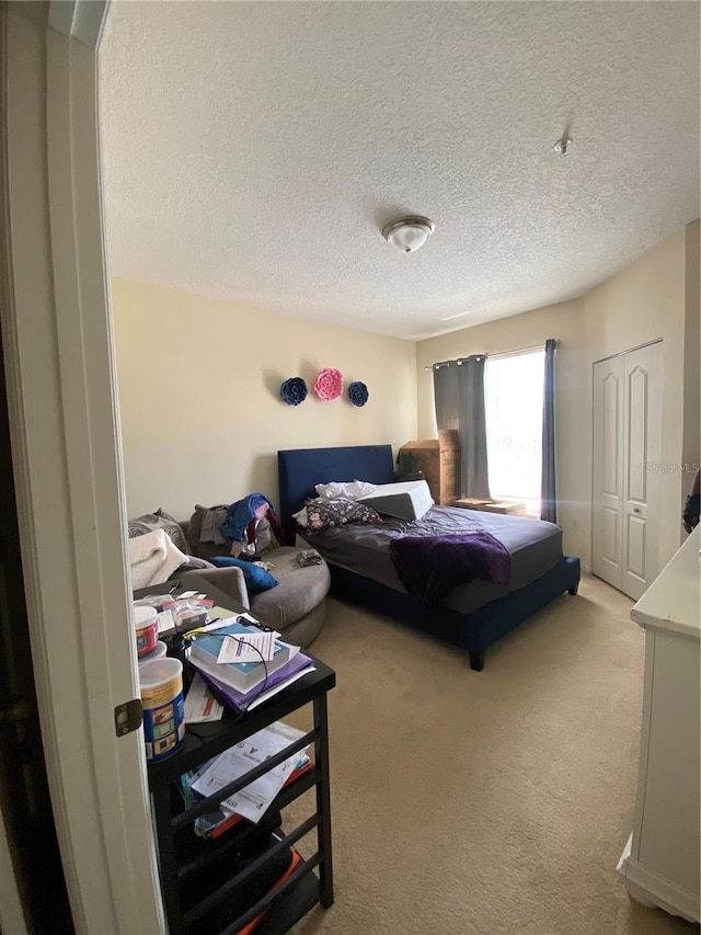 carpeted bedroom featuring a closet and a textured ceiling