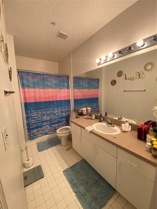 bathroom with toilet, tile patterned flooring, a textured ceiling, and vanity