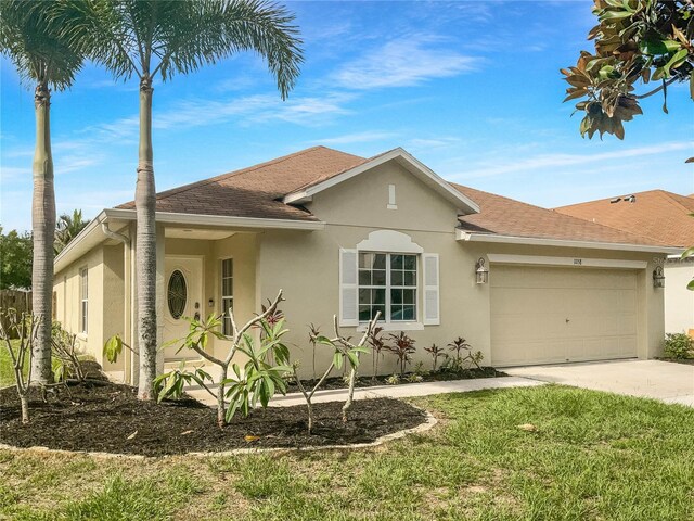 ranch-style home with a garage and a front lawn