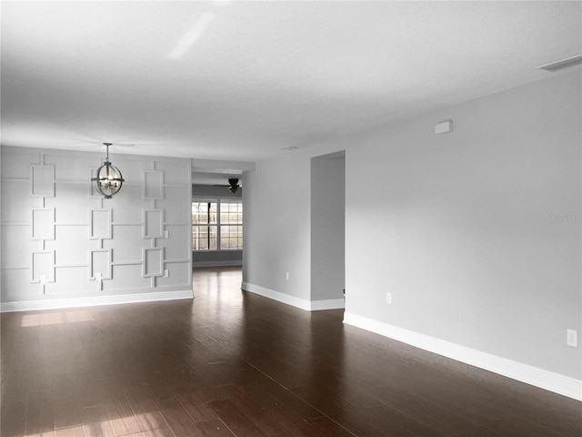 unfurnished room with dark hardwood / wood-style floors and a notable chandelier