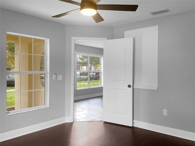 empty room with dark hardwood / wood-style floors and ceiling fan