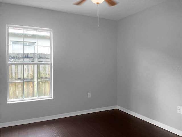 empty room featuring ceiling fan, plenty of natural light, and wood-type flooring