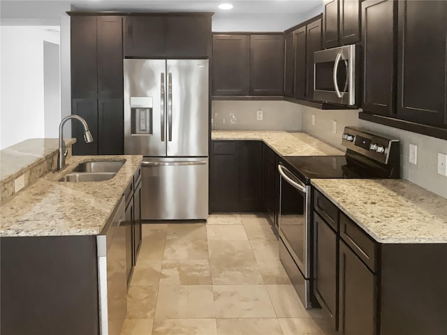 kitchen featuring dark brown cabinetry, sink, stainless steel appliances, light stone counters, and light tile patterned flooring