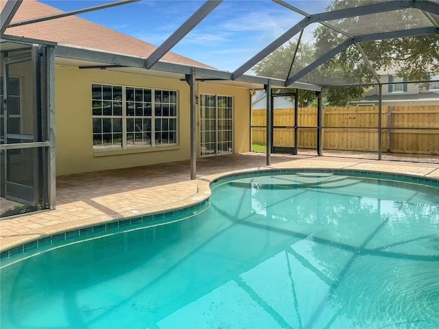 view of pool with a patio and glass enclosure