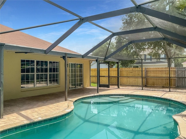 view of swimming pool with glass enclosure and a patio area