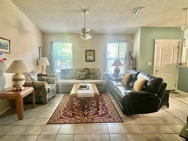 tiled living room featuring a textured ceiling and ceiling fan