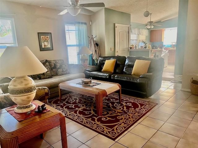 living room with ceiling fan, a healthy amount of sunlight, light tile patterned floors, and a textured ceiling