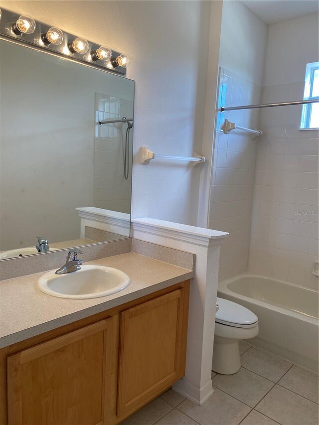 full bathroom with vanity, tile patterned floors, tiled shower / bath, and toilet