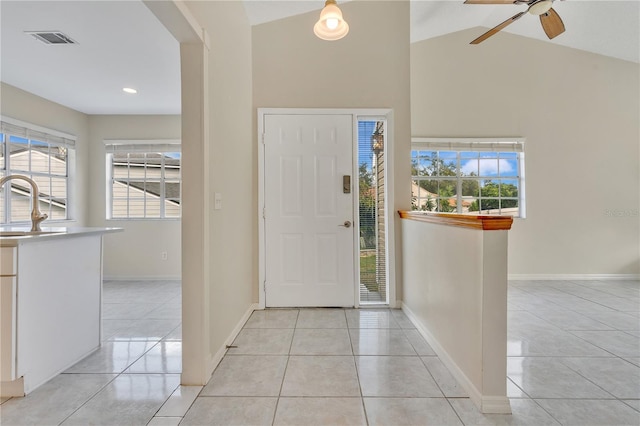 tiled entrance foyer with ceiling fan, sink, and lofted ceiling