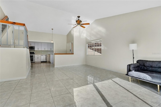 tiled living room with ceiling fan and high vaulted ceiling