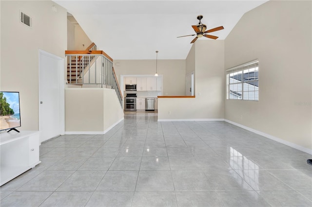 unfurnished living room with ceiling fan and high vaulted ceiling