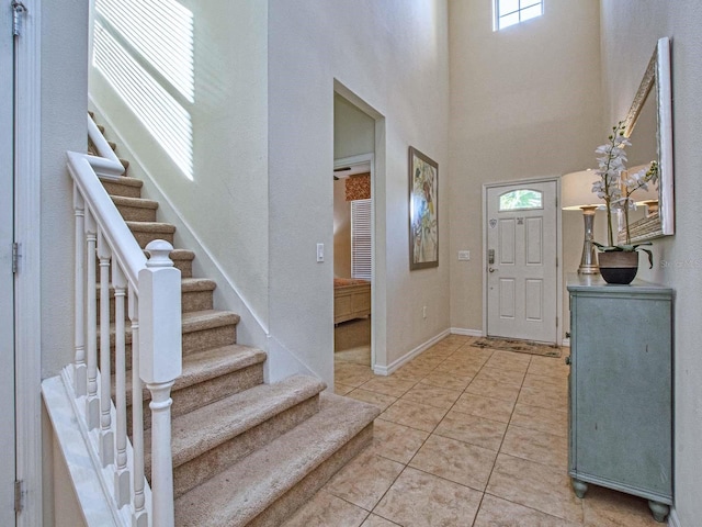 tiled foyer entrance with a healthy amount of sunlight and a towering ceiling