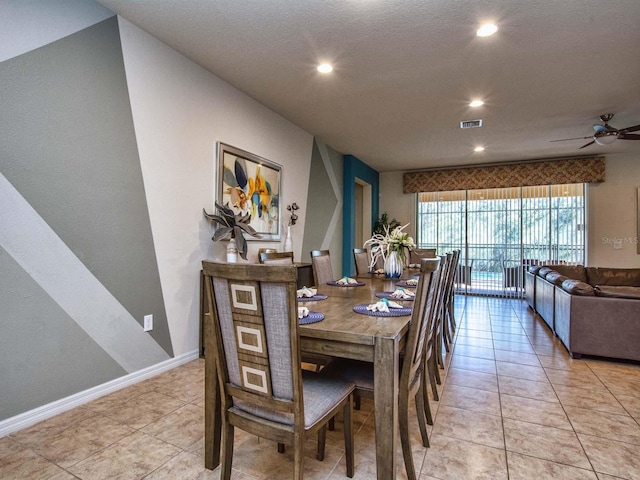 dining area with a textured ceiling, light tile patterned floors, and ceiling fan