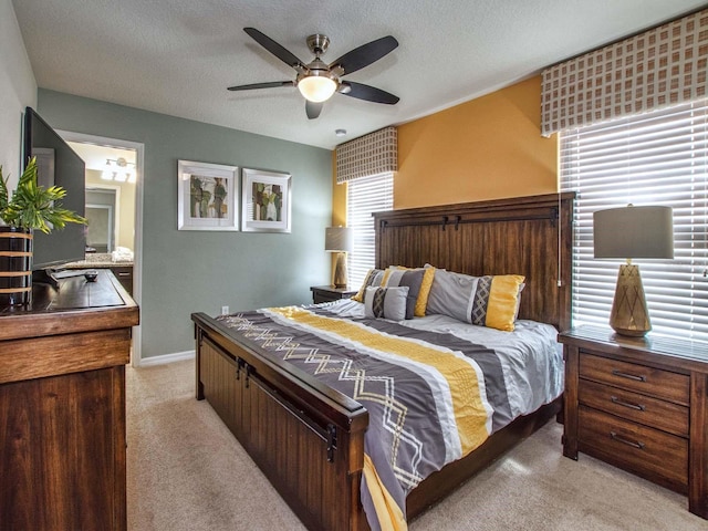 carpeted bedroom with ensuite bath, a textured ceiling, and ceiling fan