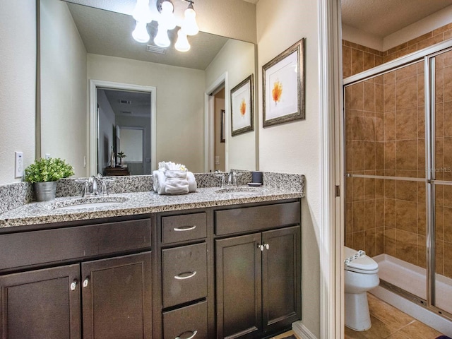 bathroom featuring a notable chandelier, double sink vanity, an enclosed shower, toilet, and tile patterned floors