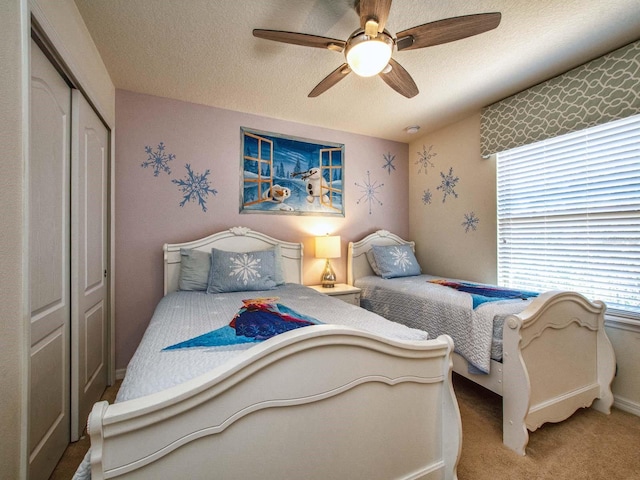 carpeted bedroom featuring a closet, a textured ceiling, and ceiling fan