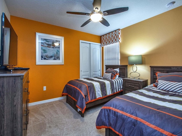 carpeted bedroom featuring a textured ceiling, a closet, and ceiling fan