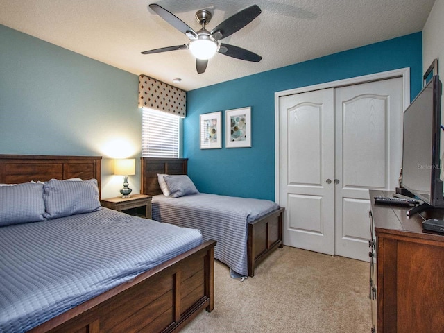 bedroom with light carpet, a textured ceiling, a closet, and ceiling fan