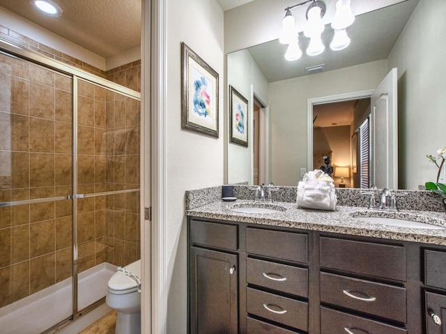 bathroom featuring double vanity, walk in shower, a textured ceiling, and toilet