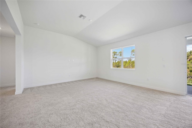 unfurnished room with lofted ceiling, visible vents, baseboards, and light colored carpet