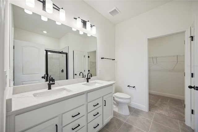 full bathroom featuring a walk in closet, a sink, a shower stall, and double vanity