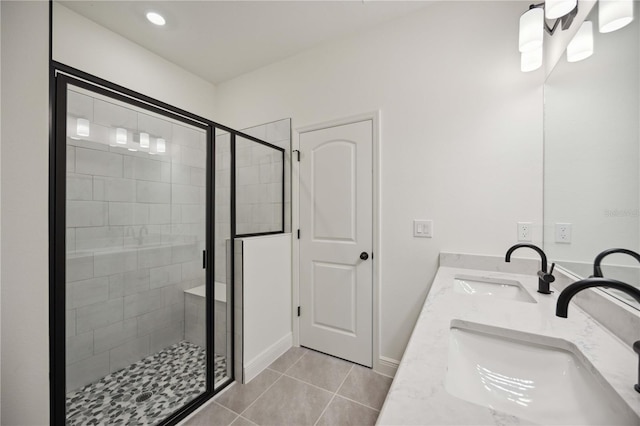 full bath featuring tile patterned flooring, a shower stall, and a sink