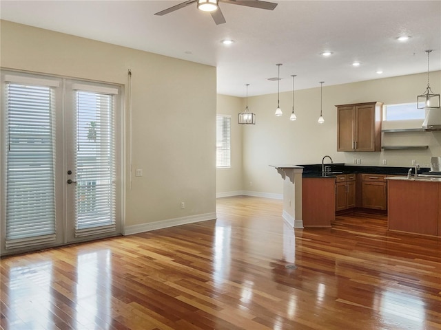 kitchen featuring pendant lighting, ceiling fan, a kitchen breakfast bar, and dark hardwood / wood-style flooring