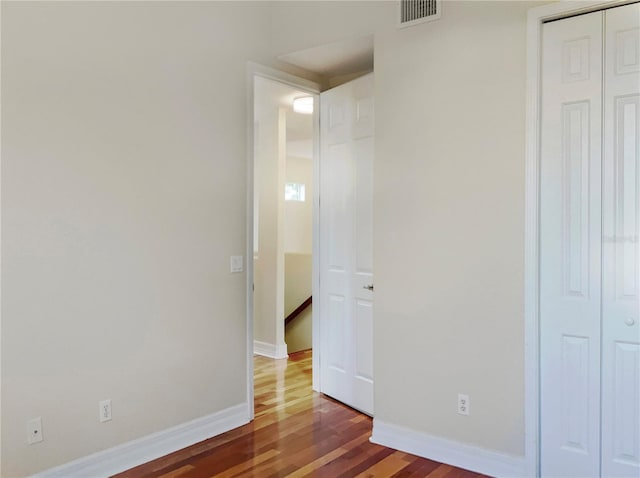 unfurnished bedroom featuring a closet and dark hardwood / wood-style floors