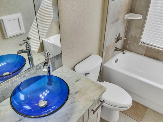 full bathroom featuring tile patterned floors, vanity, toilet, and tiled shower / bath combo