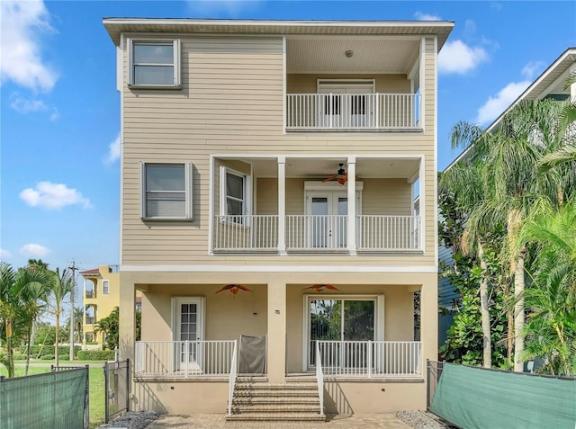 view of front of home with ceiling fan and a balcony