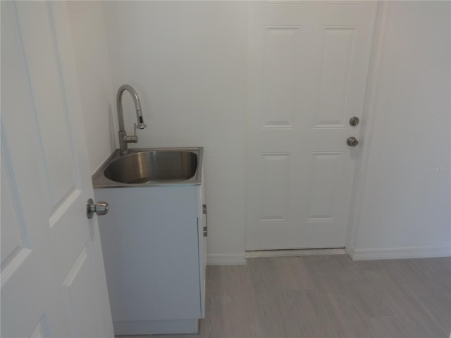 laundry area featuring light hardwood / wood-style floors and sink