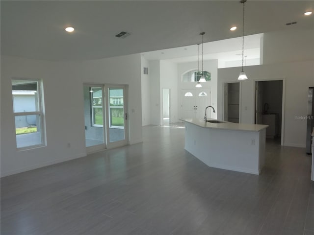 531 Rhodes Dr, Deland, FL 32720 - kitchen with open floor plan, wood finished floors, an island with sink, hanging light fixtures, and recessed lighting
