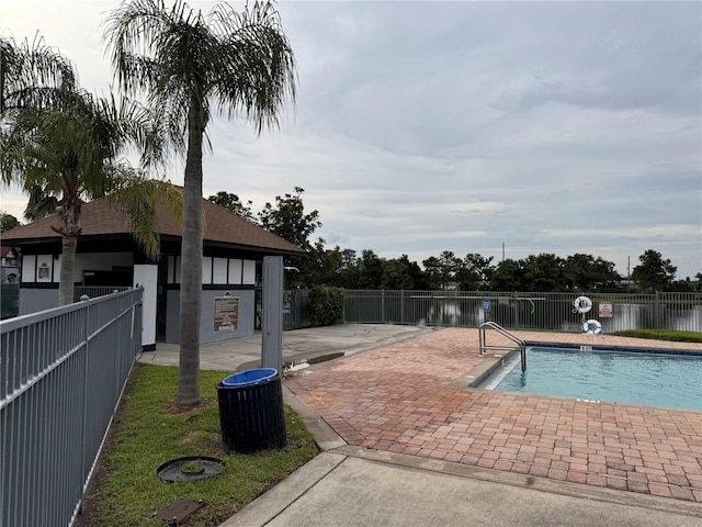 view of pool with a patio and a water view