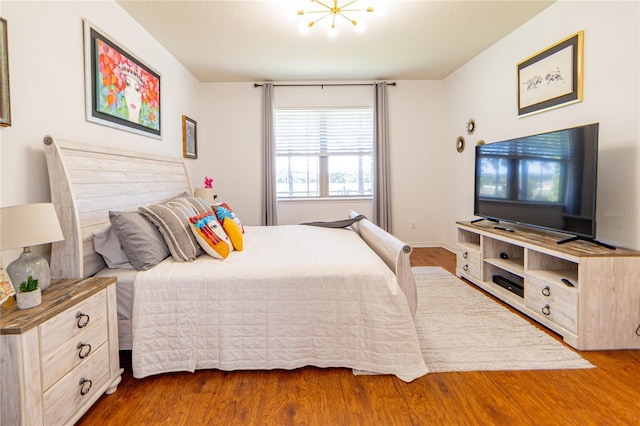 bedroom featuring hardwood / wood-style floors and a notable chandelier