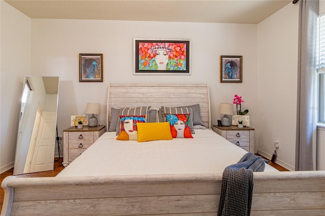 bedroom with wood-type flooring and multiple windows